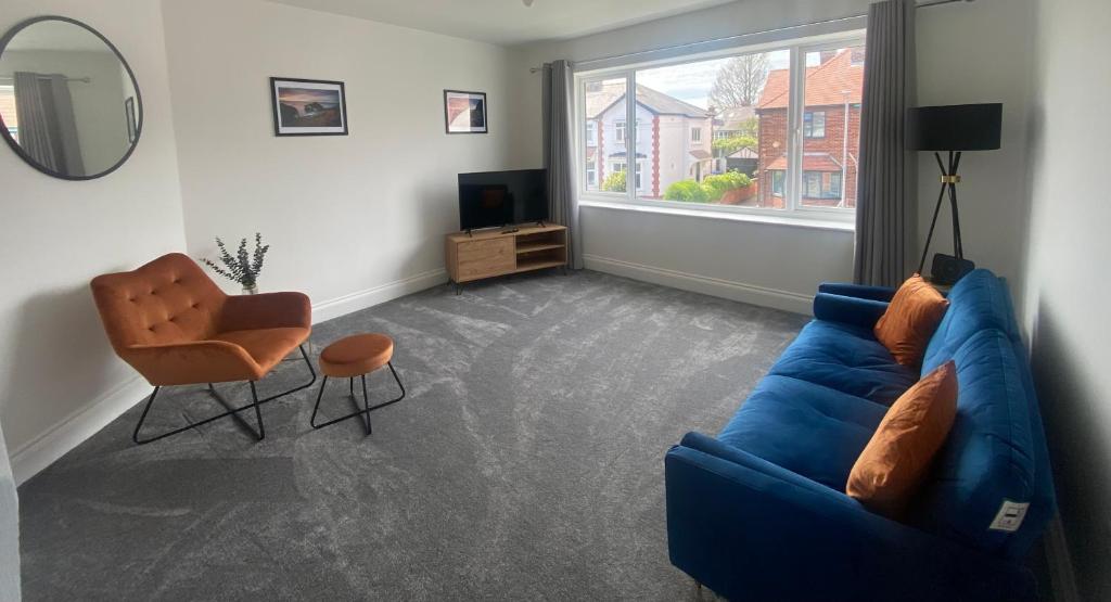 a living room with a blue couch and a chair at Bridlington Shore Apartment in Bridlington