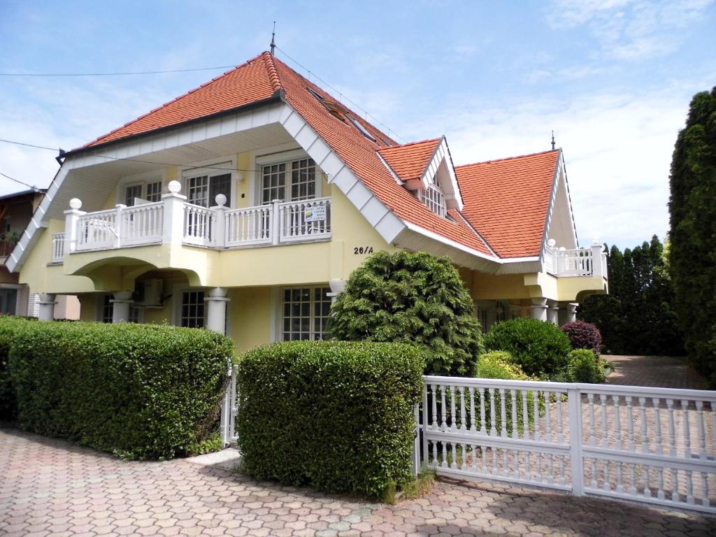 a white fence in front of a house at Millennium Villa in Keszthely