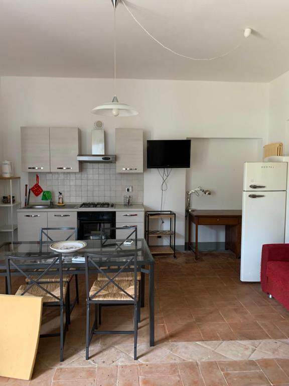 a kitchen with a table and a white refrigerator at La Maremmana in Talamone