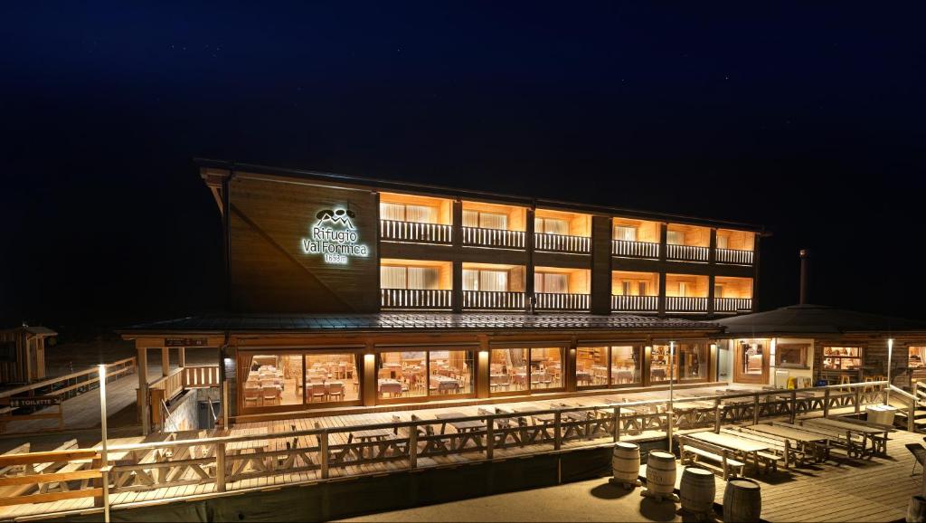 a large building with tables and chairs at night at RESORT VALFORMICA in Asiago