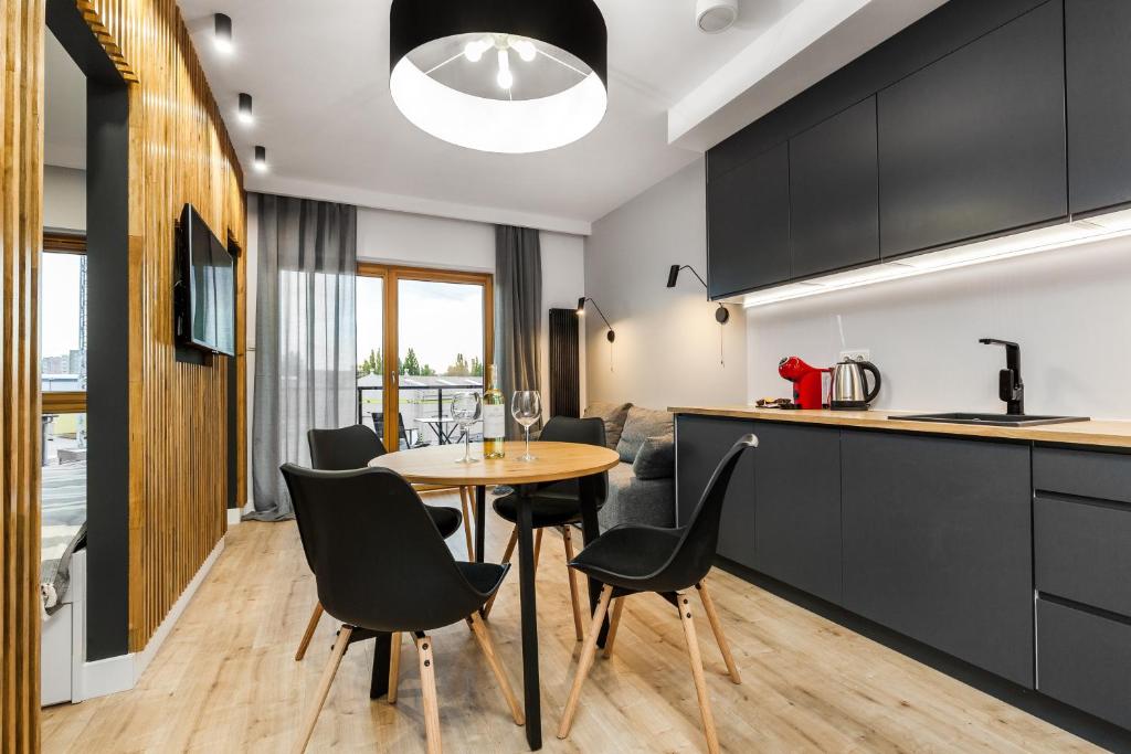 a kitchen and dining room with a table and chairs at Uroczy Apartament w Sercu Starego Miasta in Gdańsk