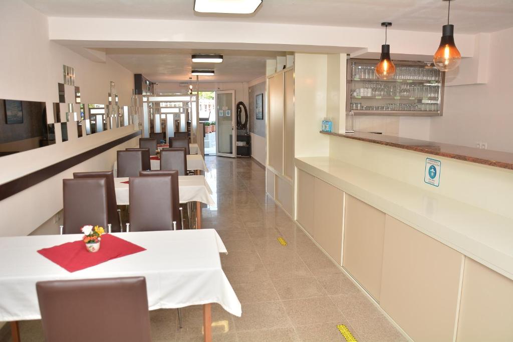 jadalnia z białymi stołami i krzesłami w obiekcie Hotel Paris w Paralii Katerinis