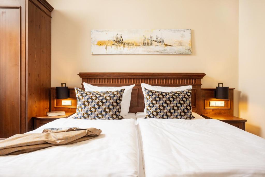 two beds with white sheets and pillows in a bedroom at Aparthotel Altes Schwedisches Konsulat in Stralsund