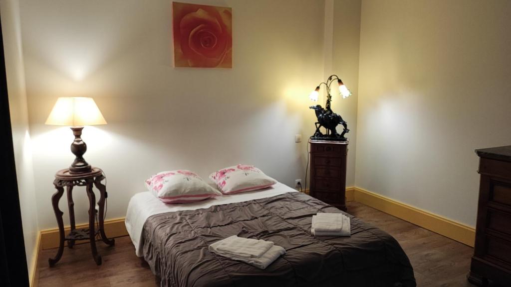1 dormitorio con 1 cama con 2 almohadas y lámpara en Gite Le Morvan, en Lormes