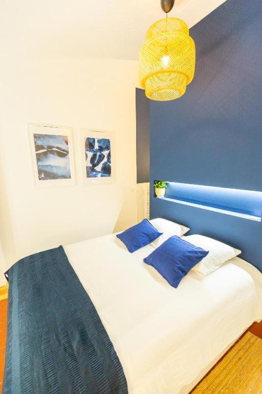 une chambre avec un grand lit aux murs bleus dans l'établissement 3 min à pied de la gare St Charles - 3 chambres avec Clim, SDB et TV, à Marseille