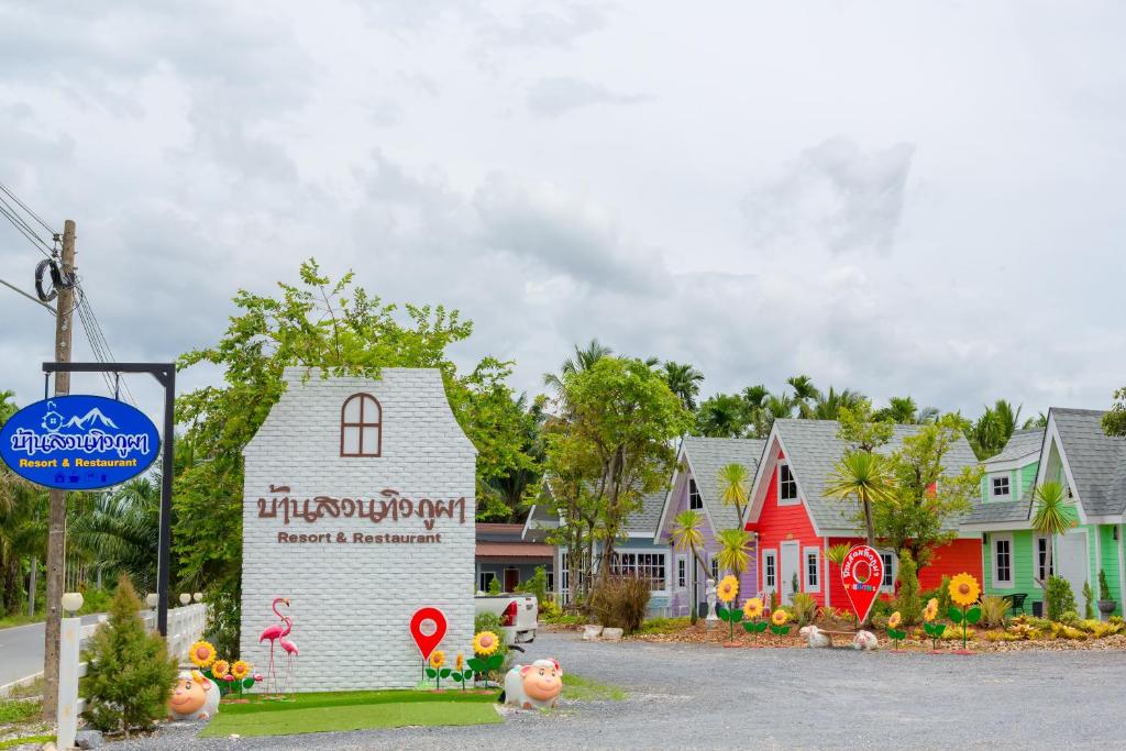 a sign in front of a group of houses at บ้านสวนทิวภูผาวัดเจดีย์ไอ้ไข่ in Ban Sai Liang