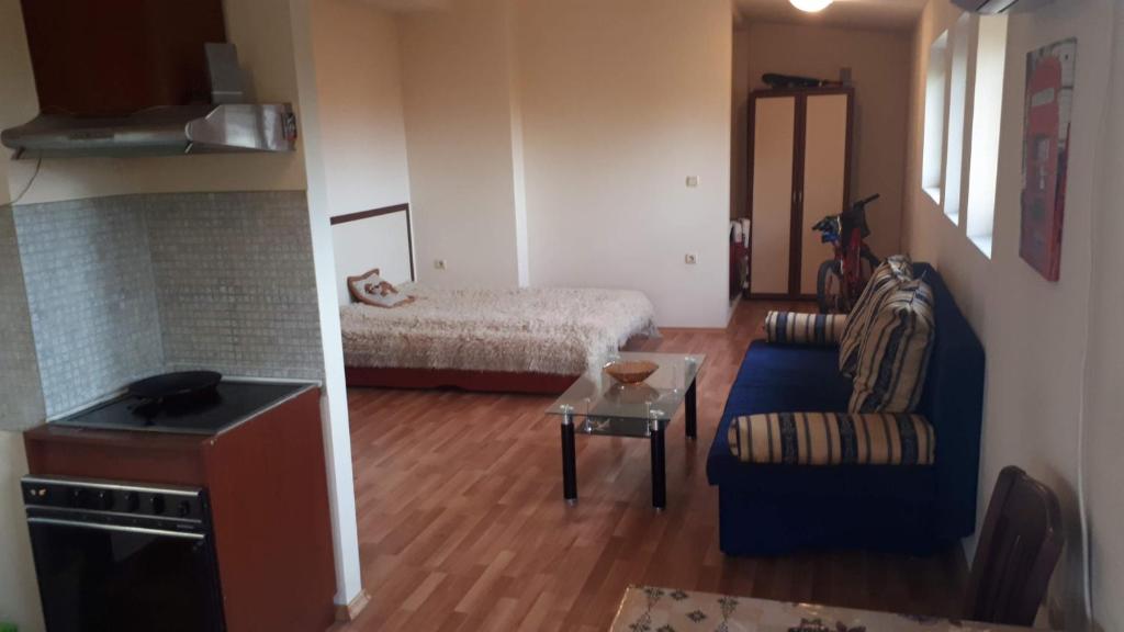 - un petit salon avec un lit et une chaise dans l'établissement Апартамент студио в затворен комплекс в гр.Банско, à Bansko
