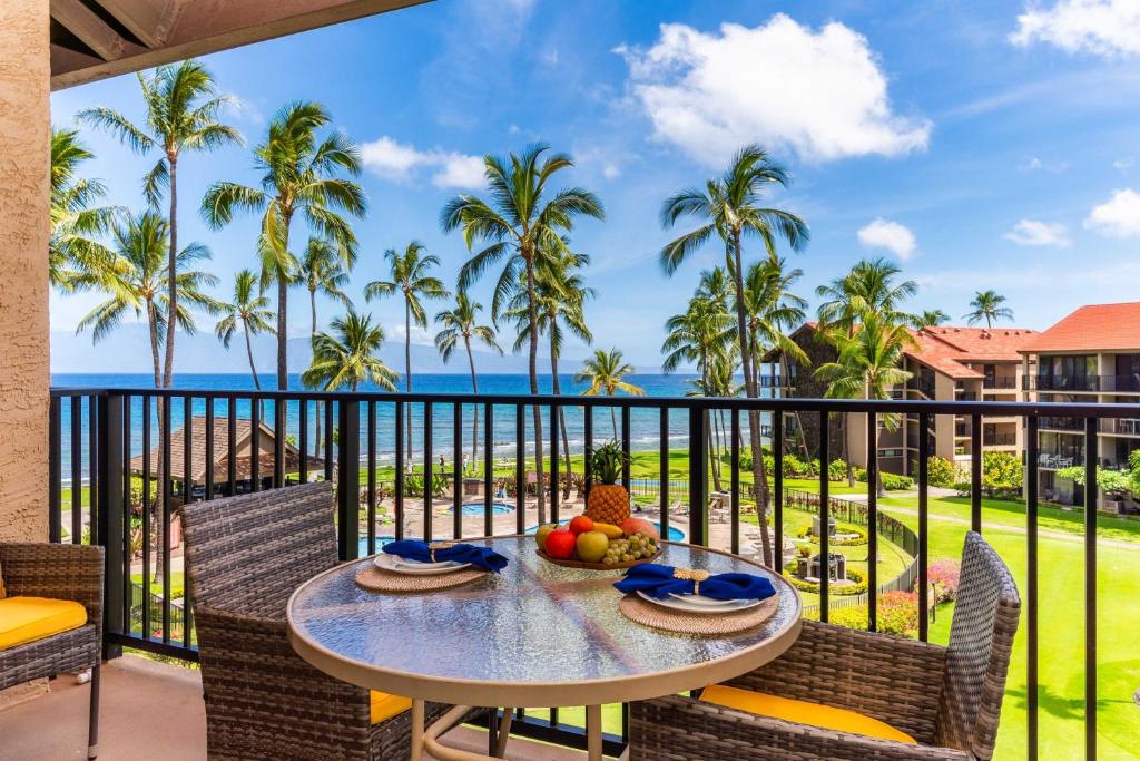 a table on a balcony with a view of the ocean at Papakea K406 OceanView 2 Bedroom 2 bath condo in Kahana