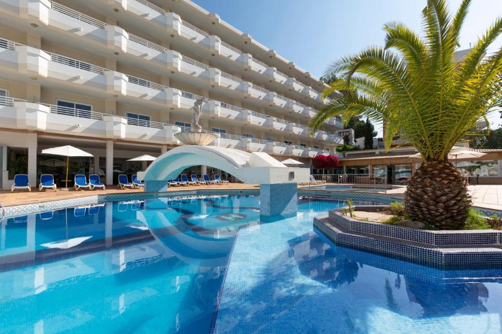 una piscina con una palmera frente a un edificio en Mar Hotels Paguera & Spa en Paguera