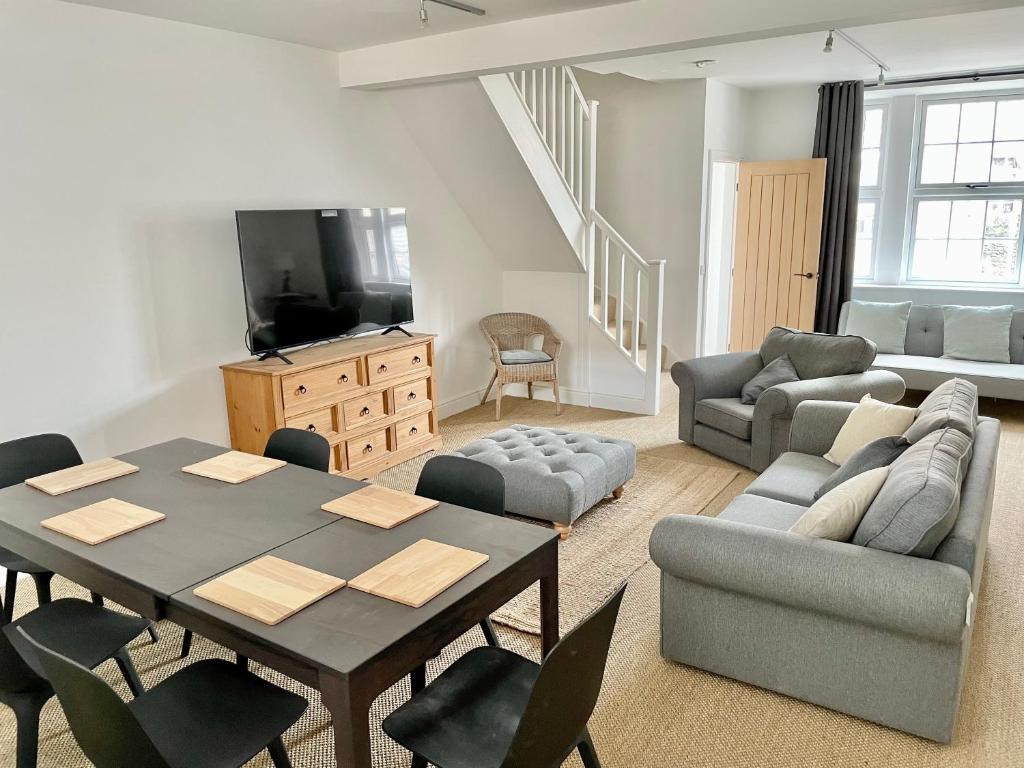 a living room with a table and chairs and a television at The Old Post Office - central Helmsley with parking in Helmsley