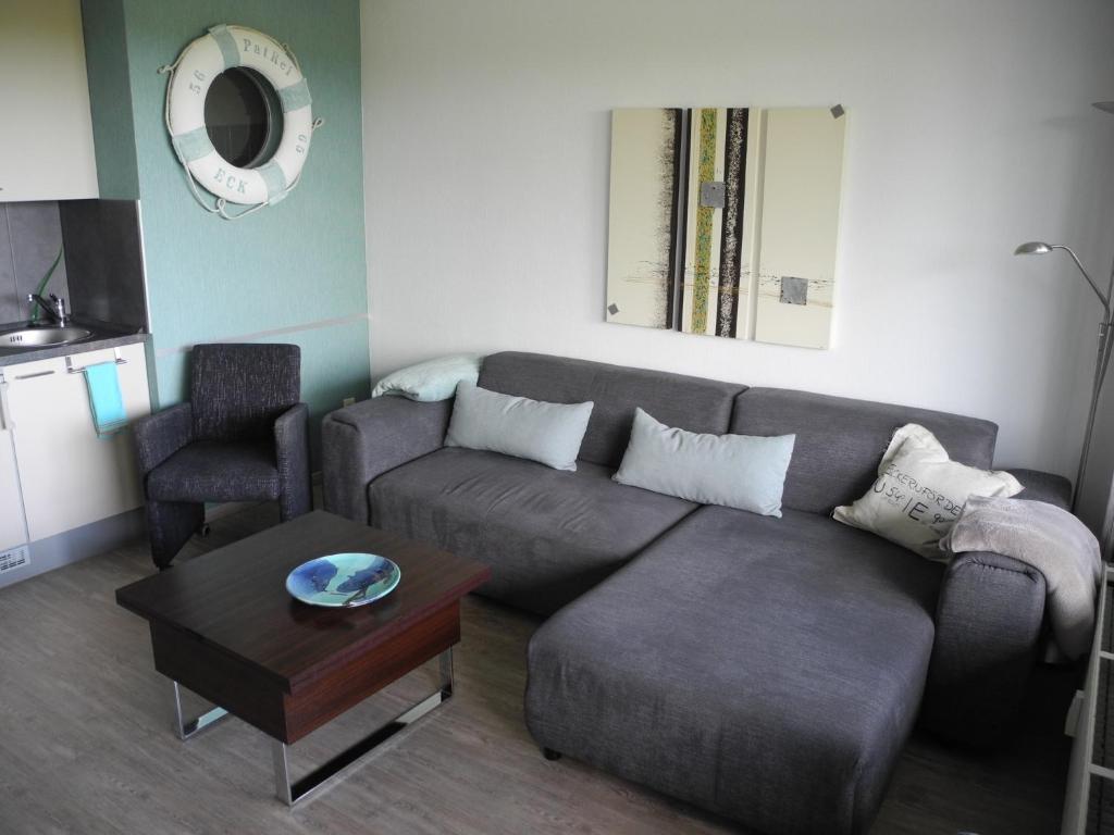 uma sala de estar com um sofá e uma mesa em PatRei mit Meerblick, auch beim Duschen em Eckernförde