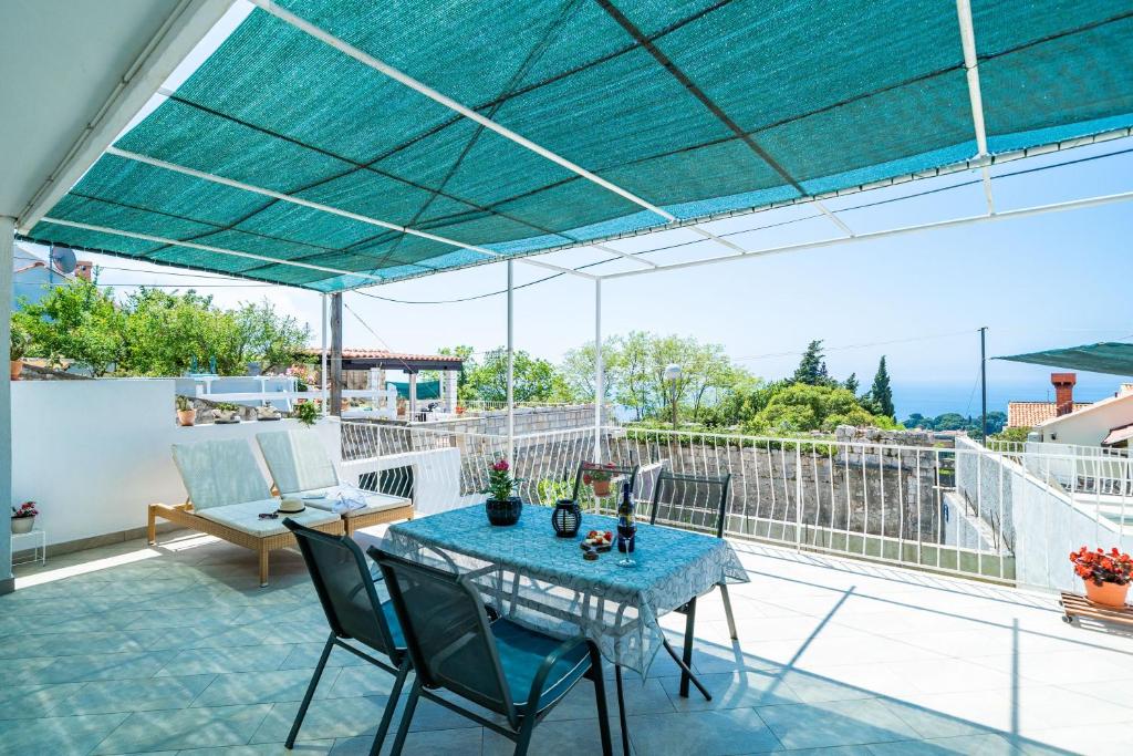 um pátio com uma mesa azul e cadeiras numa varanda em Apartments Nico em Dubrovnik