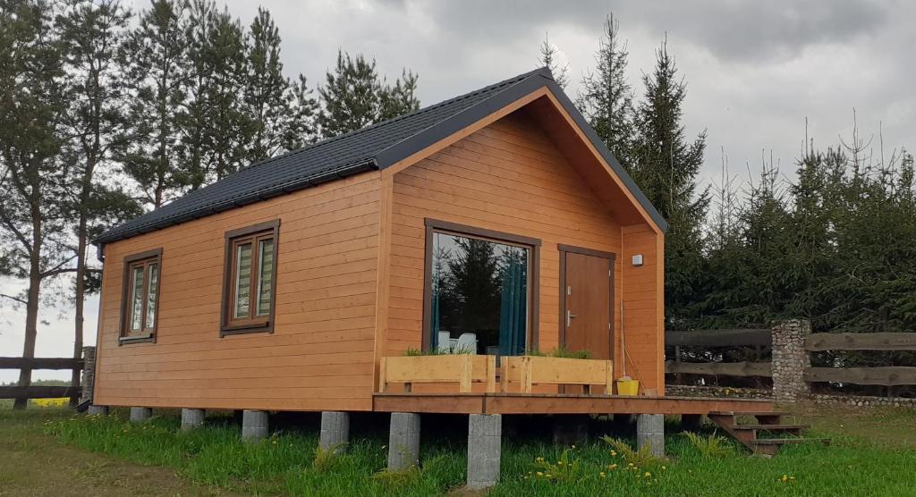 a tiny house on a wooden platform in a field at Domek wypoczynkowy nad Jez. Dadaj in Biskupiec