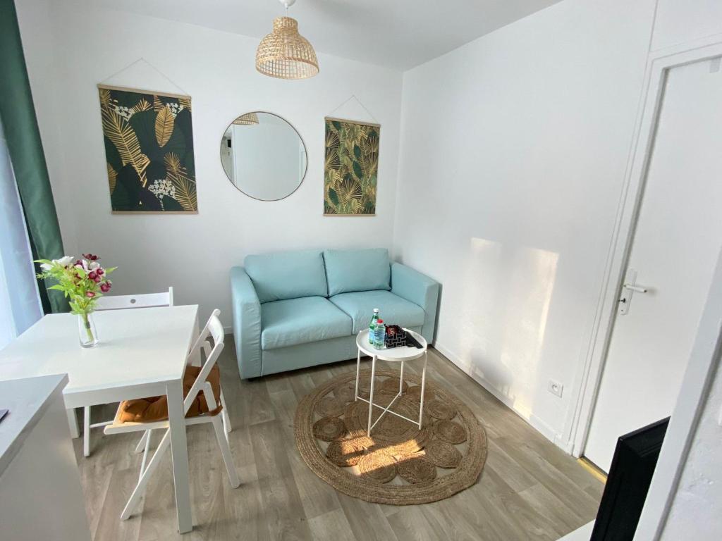 a living room with a blue couch and a table at Appartement Gare de Meaux - Proche Disney /Paris in Meaux