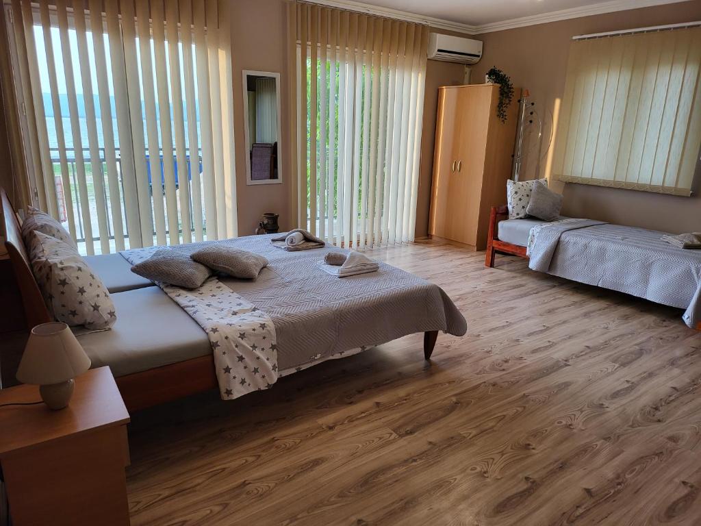 a bedroom with a bed and a couch and windows at Sun and river Apartments in Golubac