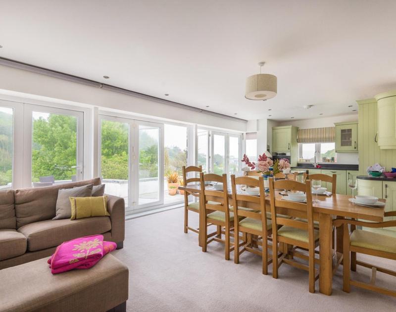 a kitchen and dining room with a table and chairs at The Wrens in Polzeath