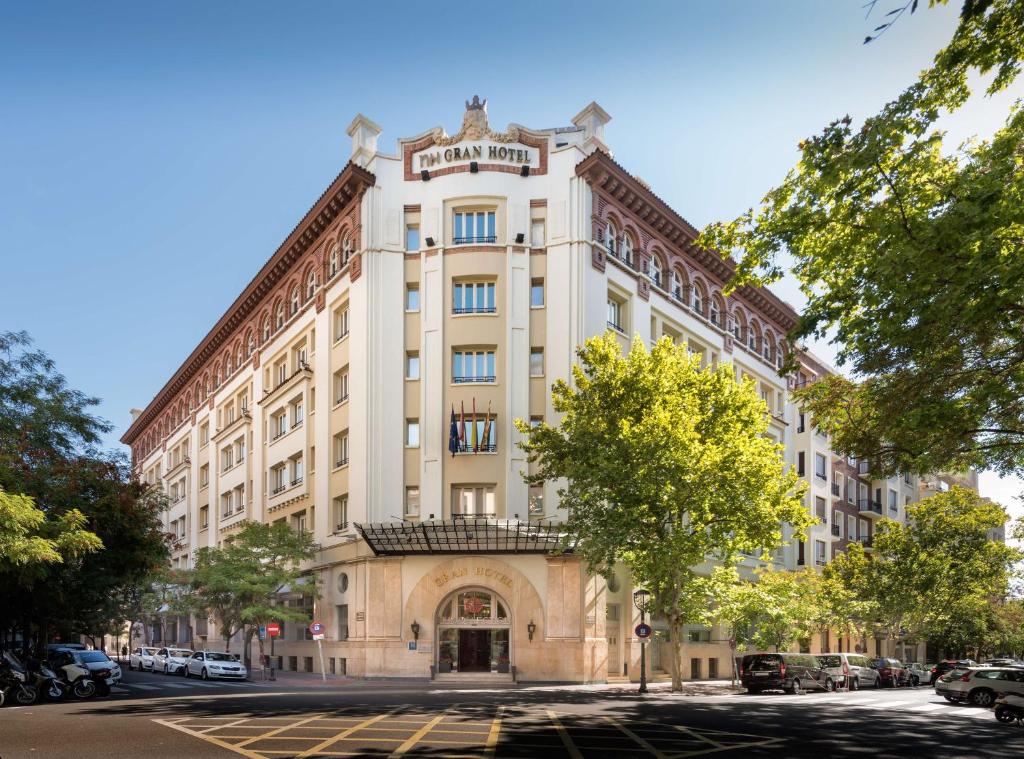 un gran edificio blanco en una calle de la ciudad en NH Collection Gran Hotel de Zaragoza, en Zaragoza