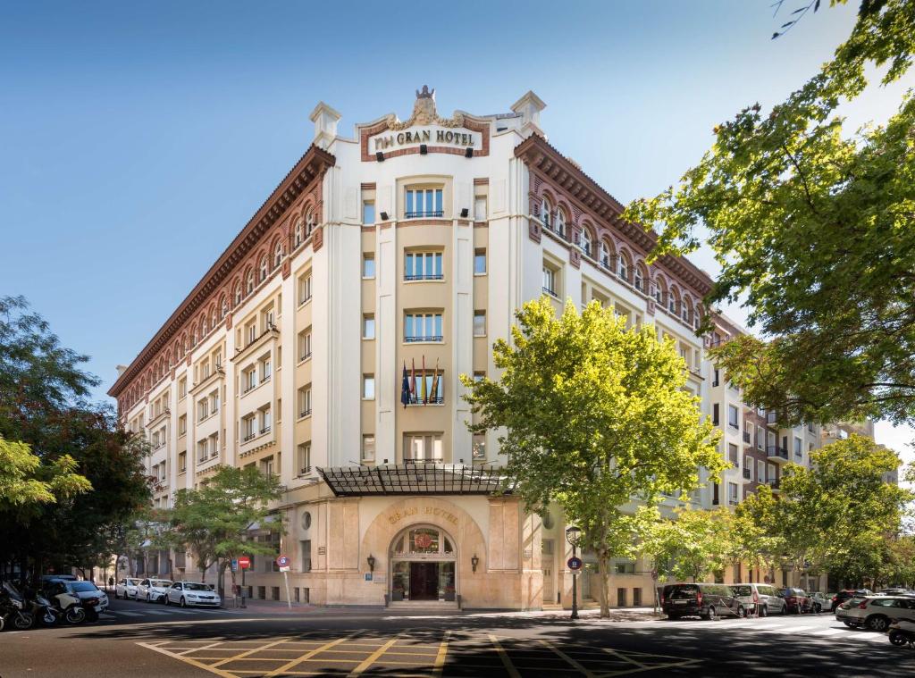 ein großes weißes Gebäude in einer Stadtstraße in der Unterkunft NH Collection Gran Hotel de Zaragoza in Saragossa