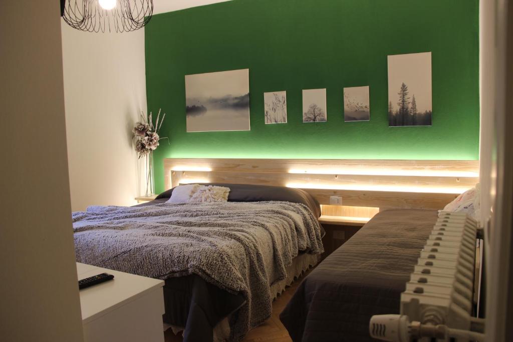 a bedroom with a green wall and two beds at B&B degli Allori in Moggiona