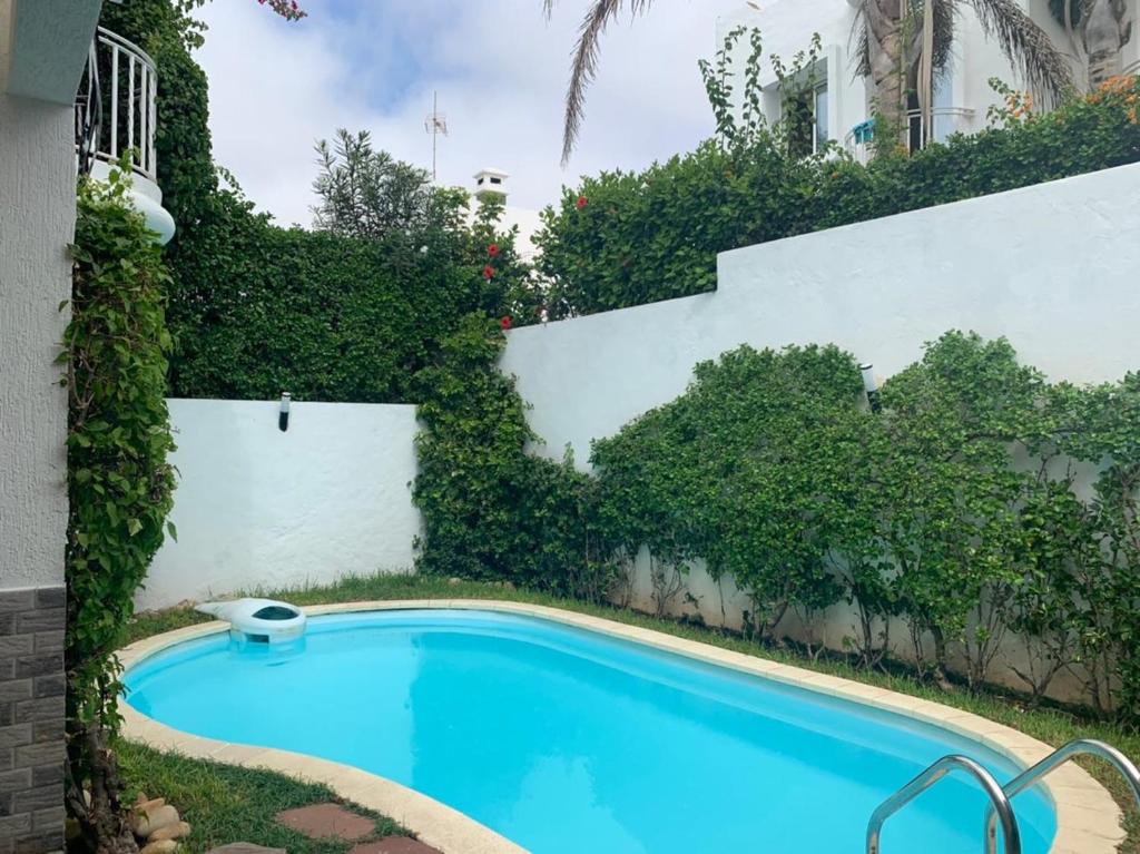 a swimming pool in the yard of a house at Villa avec piscine privée près de Casablanca Maroc in Dar Bouazza