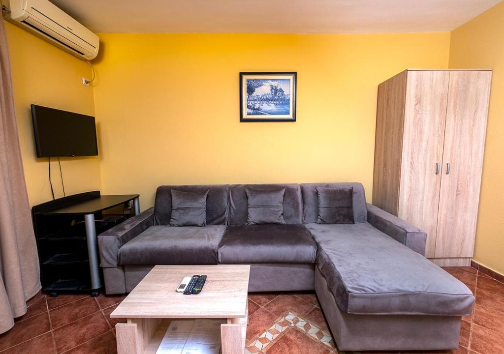 uma sala de estar com um sofá e uma mesa em APARTMANI VUKADINOVIC LUX em Budva