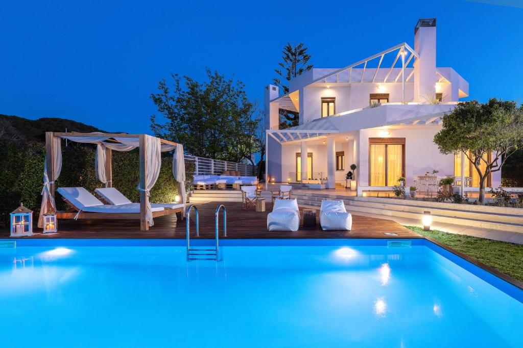 a villa with a swimming pool at night at Love White Villa in Ialysos