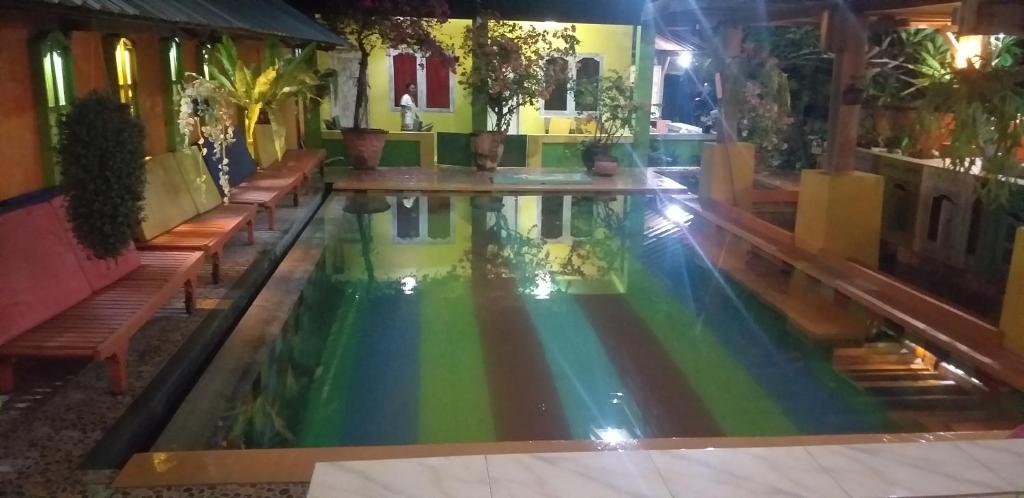 uma piscina com um arco-íris no meio de uma casa em Alola inn em Padangbai