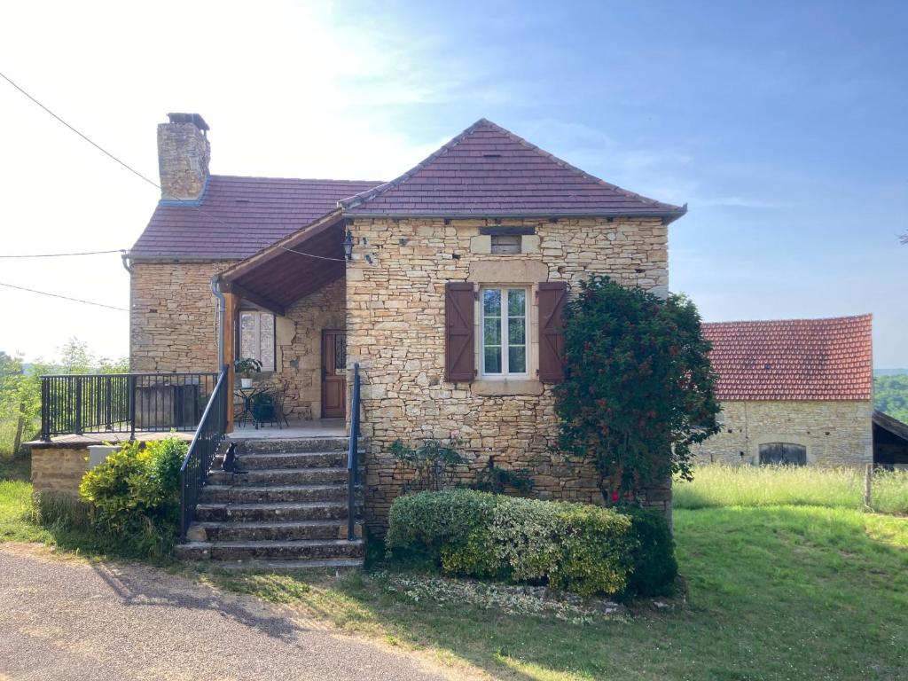 a small brick house with stairs in front of it at maison de campagne en pierre in Dégagnac