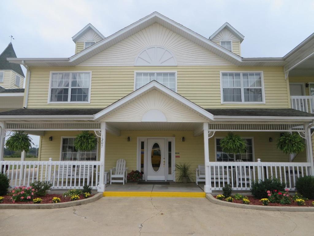 een geel huis met een wit hek bij Honeysuckle Inn in Mountain View