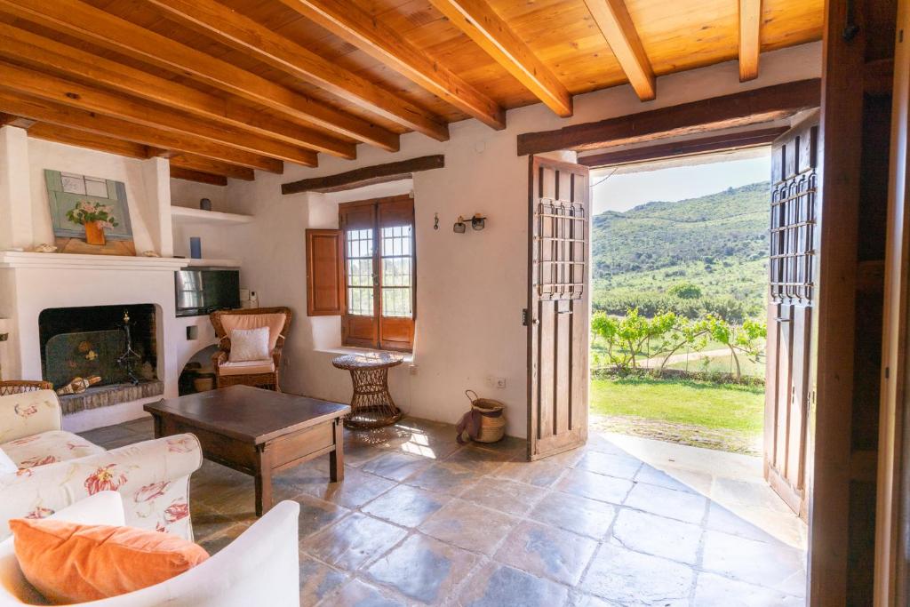 a living room with a fireplace and an open door at Finca Sta Teresa, Casa Grande in Estepona