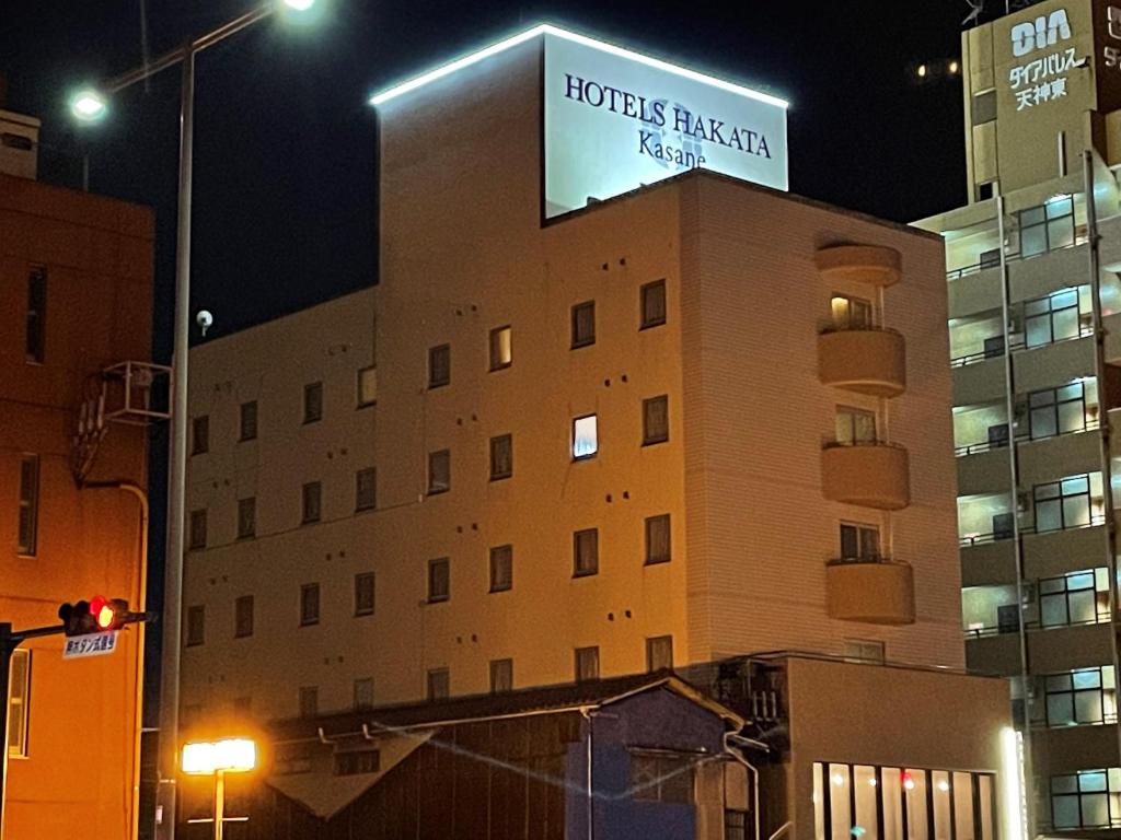 a building with a sign on top of it at night at THE HOTELS HAKATA KASANE Bayside in Fukuoka