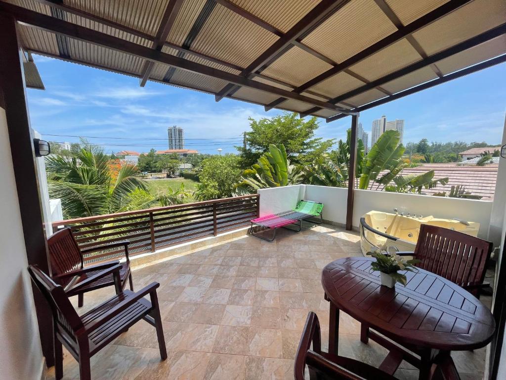 a patio with a table and chairs on a balcony at Relax and Rejuvenate in Rayong! in Rayong