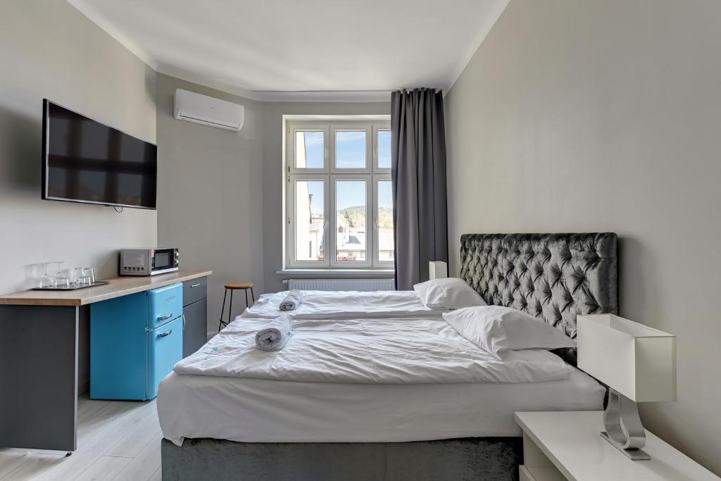 a bedroom with a large bed and a desk at La Casa del Grand Apartments Sopot in Sopot