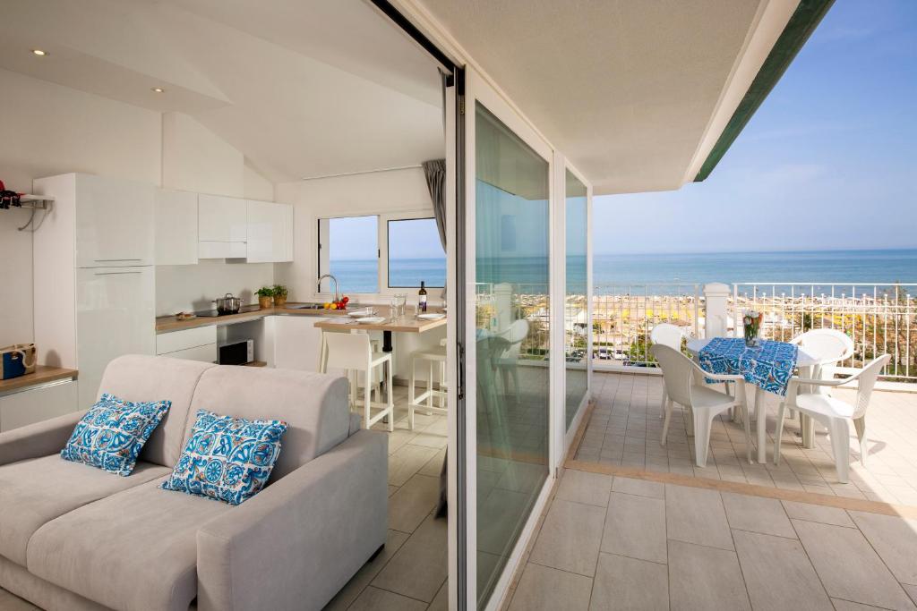 un soggiorno con divano e vista sull'oceano di Rubino Apartments a 100metri dal mare a Riccione
