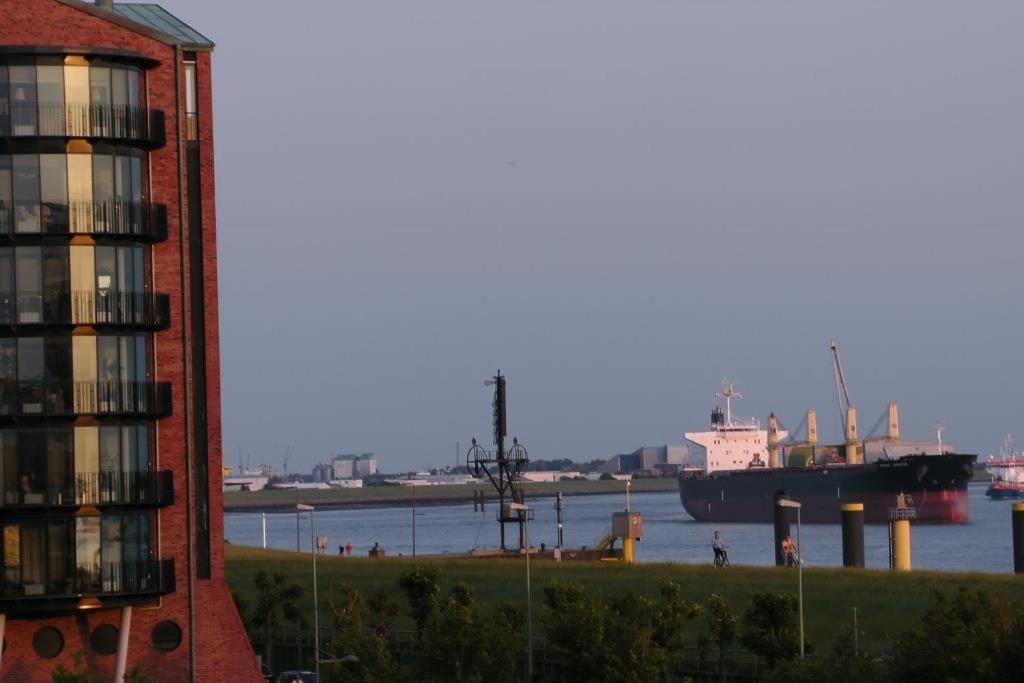 un gran barco en el agua junto a un edificio en NewPort Weser, NewPort Marina en Bremerhaven