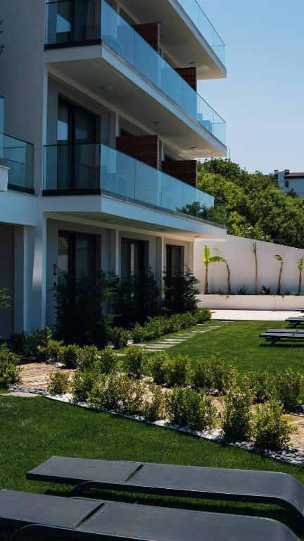 a large white building with a lawn in front of it at KADAGAN SUİTES AYASARANDA in Çeşme