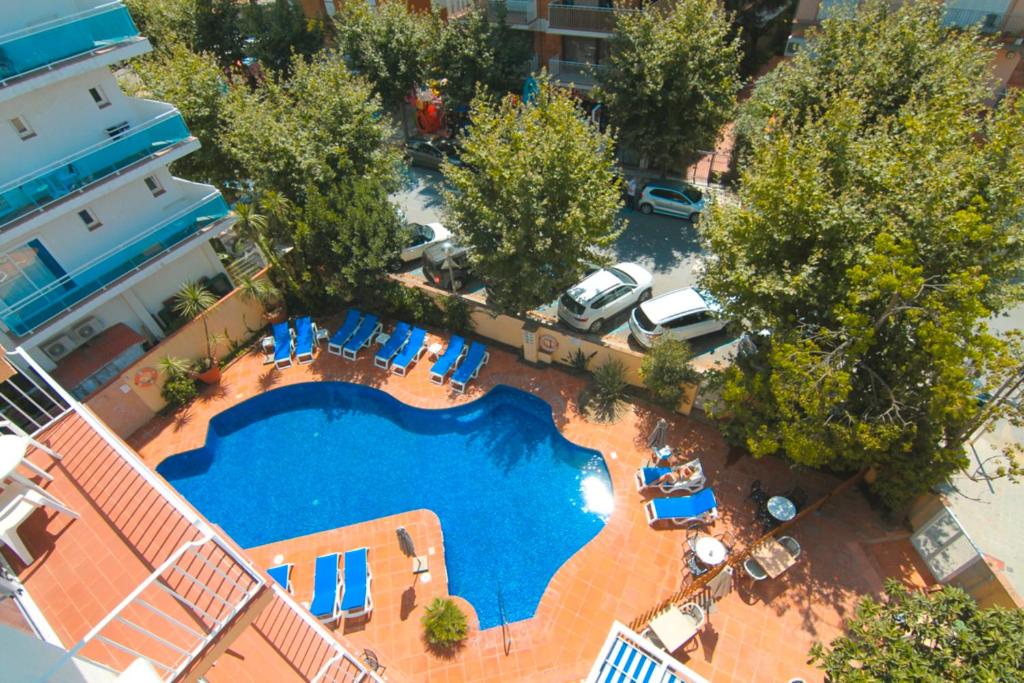 uma vista sobre uma piscina com cadeiras e árvores em Hotel Dwo Les Palmeres em Calella