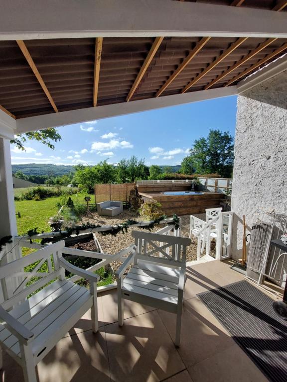 een patio met stoelen en uitzicht op een tuin bij Arc de l'amour in Youx