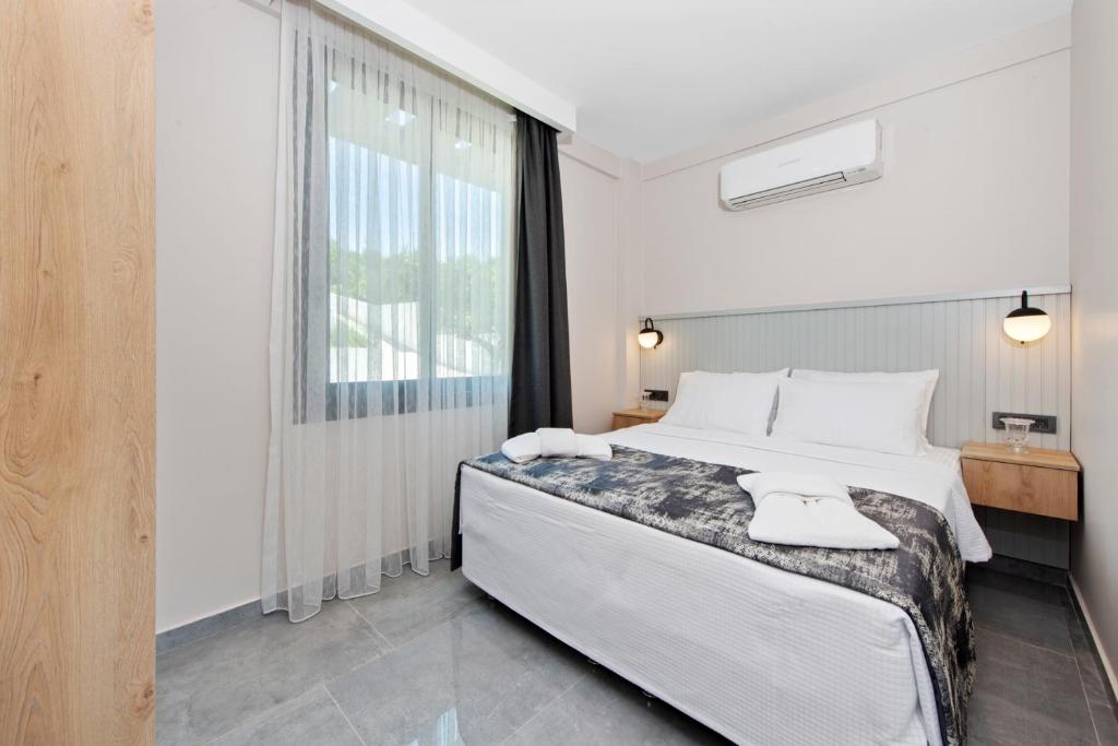 a bedroom with a large bed and a window at KADAGAN SUİTES AYASARANDA in Çeşme