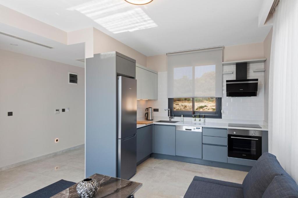 a kitchen with gray cabinets and a window at KADAGAN SUİTES AYASARANDA in Çeşme