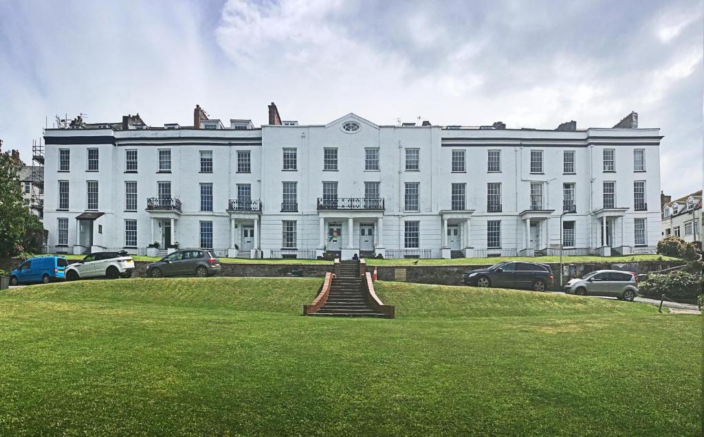 a large white building with a lawn in front of it at Ilfracombe Townhouse: restored historic home in Ilfracombe