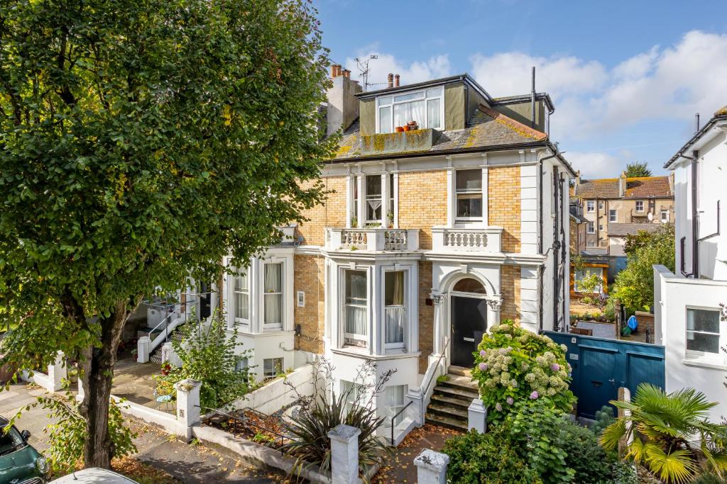 een groot wit huis met een balkon bij Spacious 2 bedroom apartment with beautiful garden in Brighton & Hove