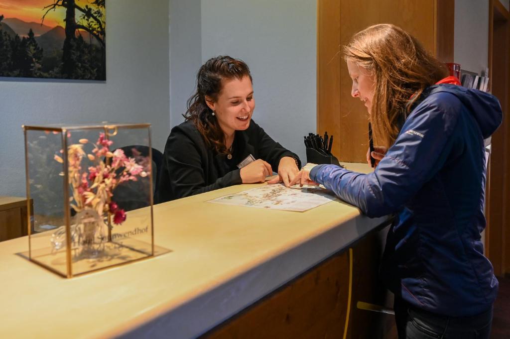 two women standing at a counter looking at a display at Hotel Sonnwendhof Engelberg in Engelberg