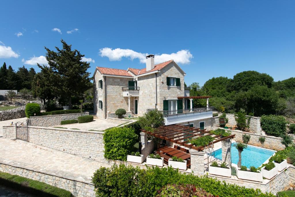 an exterior view of a house with a swimming pool at Villa Demi in Pučišća