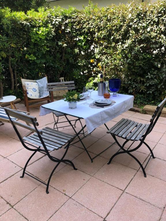 une table avec deux chaises ainsi qu'une table et des chaises blanches dans l'établissement ATYPIQUE T2 de 35 m avec JARDIN proche de la MER, à Arcachon