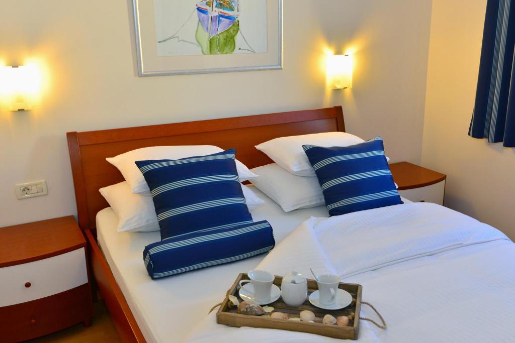 a bedroom with two beds with blue and white pillows at Villa Dalmatina in Živogošće