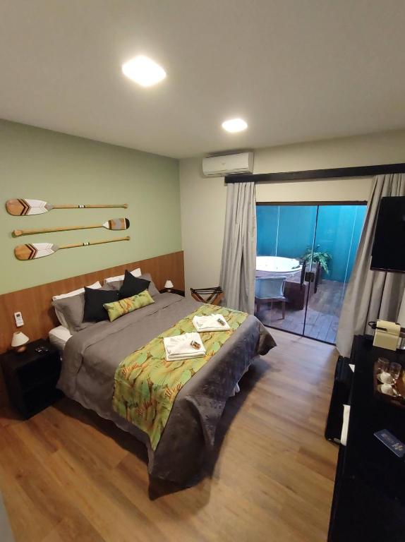 um quarto com uma cama e uma casa de banho com uma banheira em Pousada Júlio Grande em Fernando de Noronha