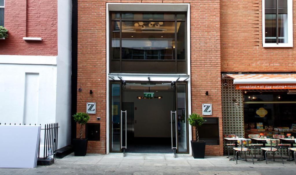 una entrada a un edificio de ladrillo con puerta de cristal en The Z Hotel Tottenham Court Road, en Londres