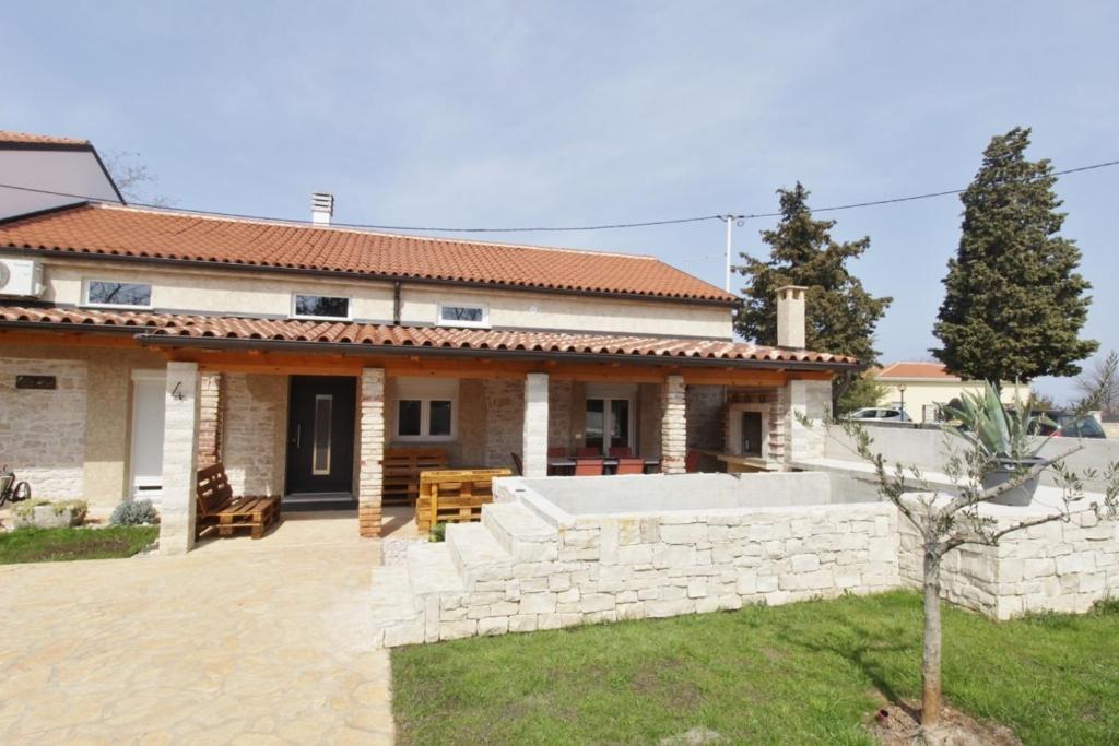 uma casa com uma parede de pedra e um quintal em Villa Alina with Pool em Savudrija