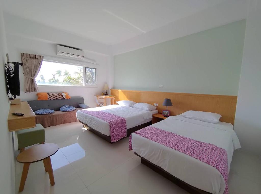 een hotelkamer met 2 bedden en een bank bij Little Molly B&B in Magong